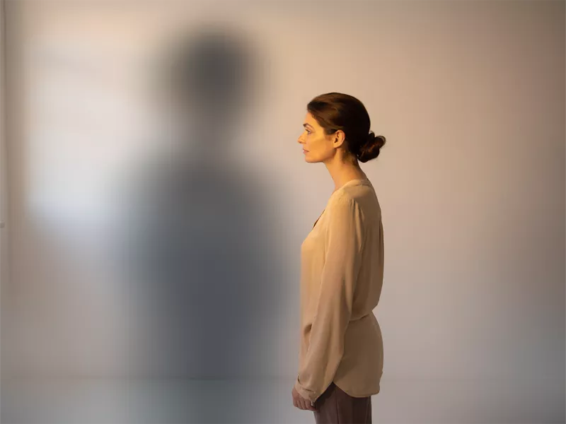 Persona observando su sombra en la pared como metáfora del miedo irracional en una fobia, representando el sistema de alarma emocional activado.
